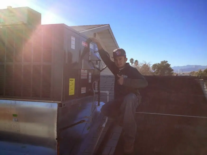 HVAC technician performing AC Tune-Up on a rooftop unit in Lomita